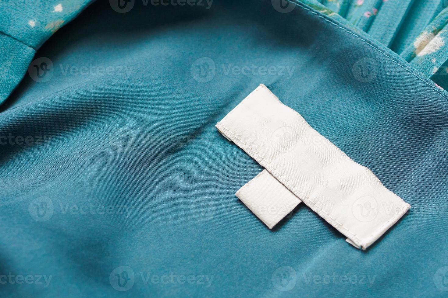 etiqueta de ropa blanca en blanco para el cuidado de la ropa sobre fondo de tela foto