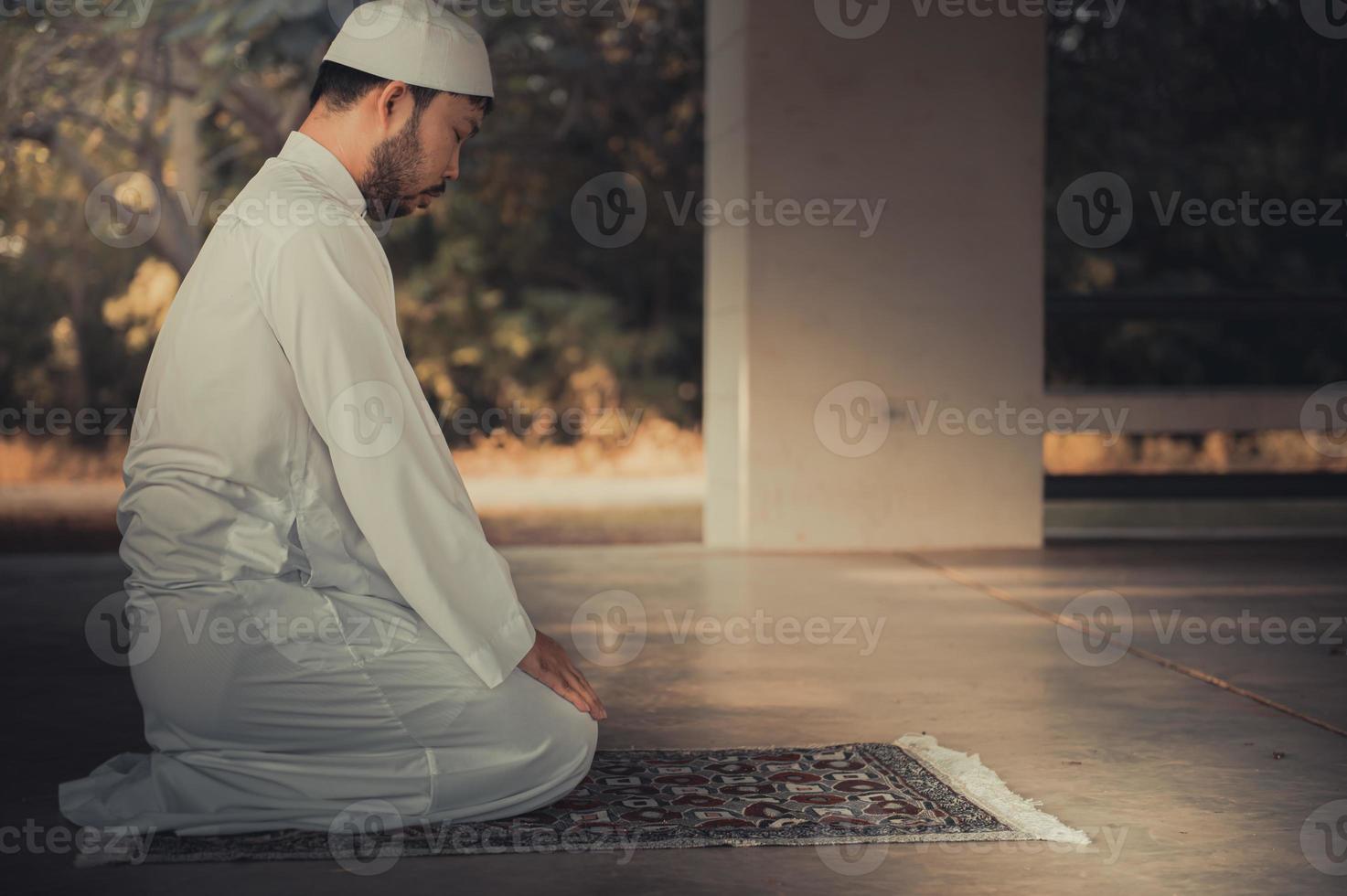 oración del hombre islámico asiático, oración musulmana joven, concepto del festival de ramadán foto