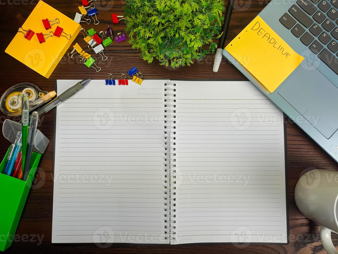 Flat lay, a mock up of a notebook. workspace in the background of the office desk from the top view. with white notebooks, laptops, office supplies, pencils, and coffee cups in the  wooden desk. photo