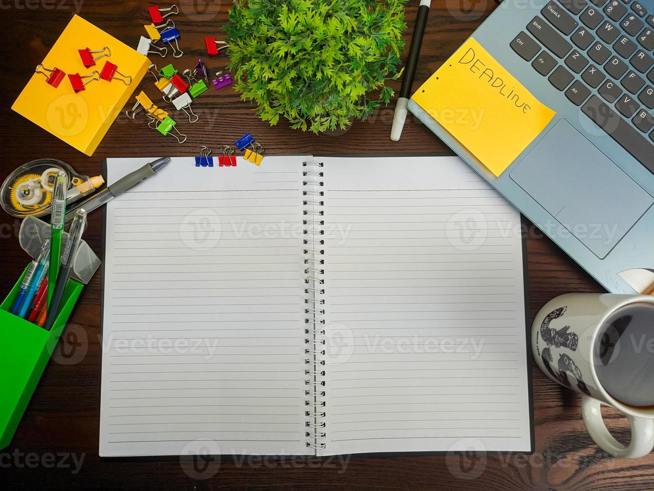 Flat lay, a mock up of a notebook. workspace in the background of the office desk from the top view. with white notebooks, laptops, office supplies, pencils, and coffee cups in the  wooden desk. photo