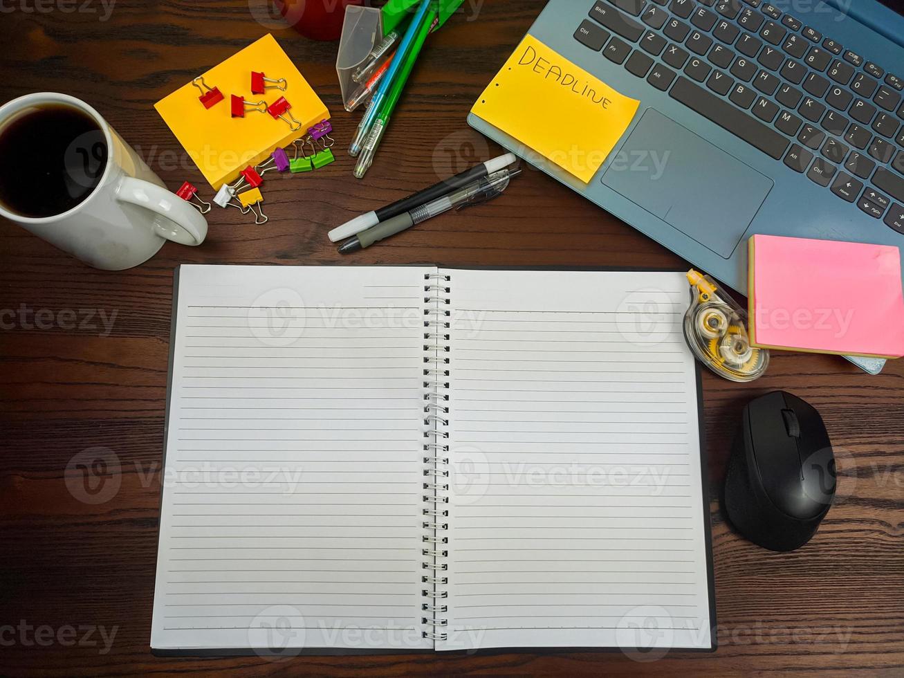 Flat lay, a mock up of a notebook. workspace in the background of the office desk from the top view. with white notebooks, laptops, office supplies, pencils, and coffee cups in the  wooden desk. photo