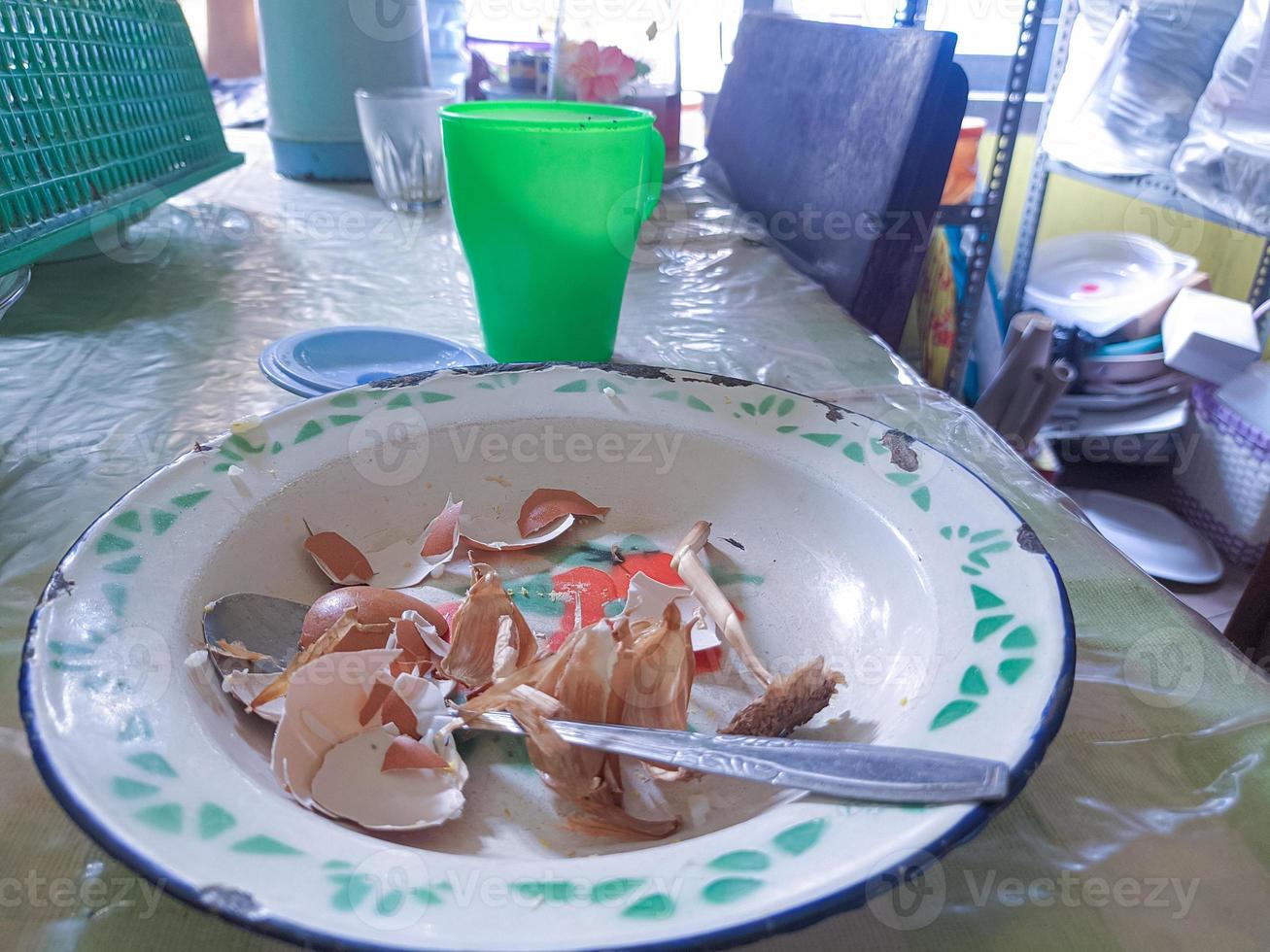 The dining table is in a mess. A messy dining table with used dishes and full of food scraps that have not been cleaned. real life. year-end photo