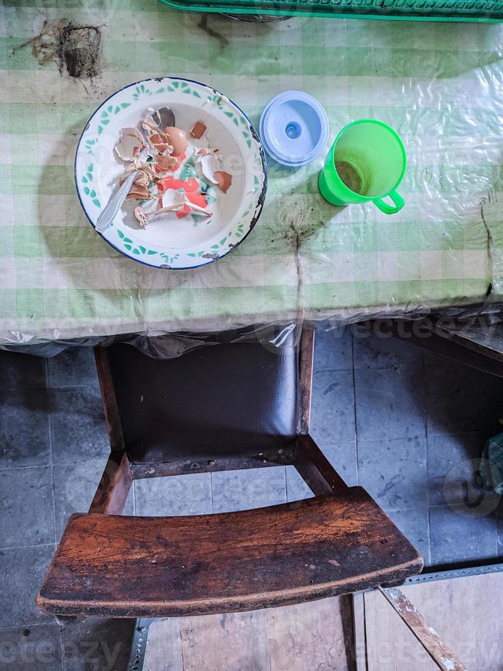 The dining table is in a mess. A messy dining table with used dishes and full of food scraps that have not been cleaned. real life. year-end photo