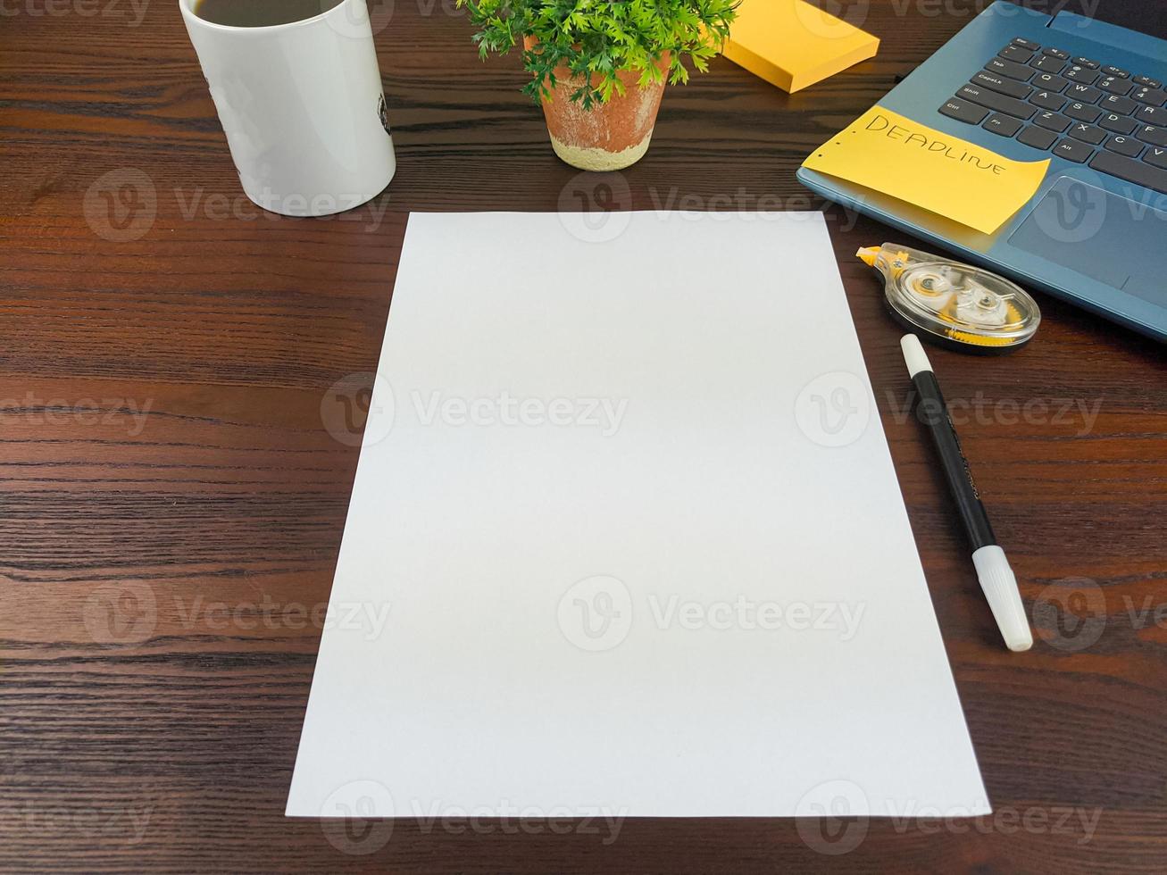 endecha plana, papel simulado. espacio de trabajo en el fondo del escritorio de la oficina desde la vista superior. con papel blanco en blanco, computadoras portátiles, material de oficina, lápices, hojas verdes y tazas de café foto