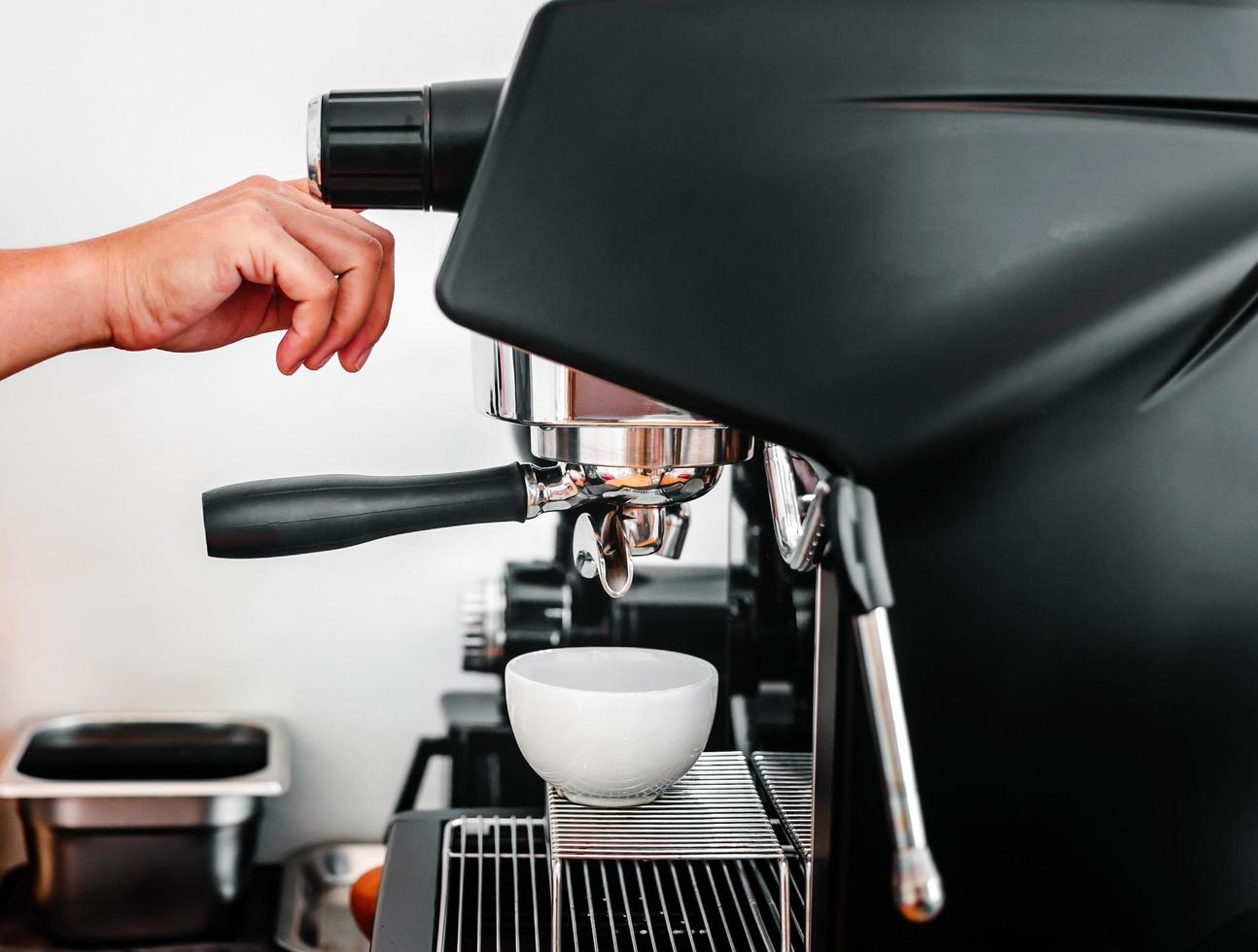 Close-up of hand barista making fresh coffee with the coffee machine in the cafe photo