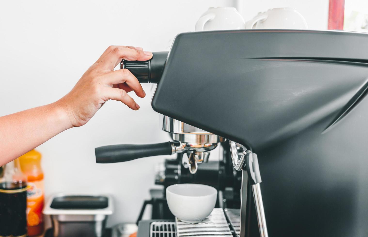 Close-up of hand barista making fresh coffee with the coffee machine in the cafe photo
