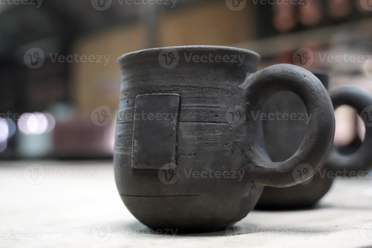 coffee mug with handle. The sculptor has already formed and prepared to lead to the incineration process. Soft and selective focus. photo