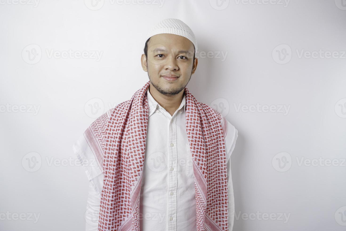 A portrait of a happy Asian Muslim man smiling isolated by white background photo