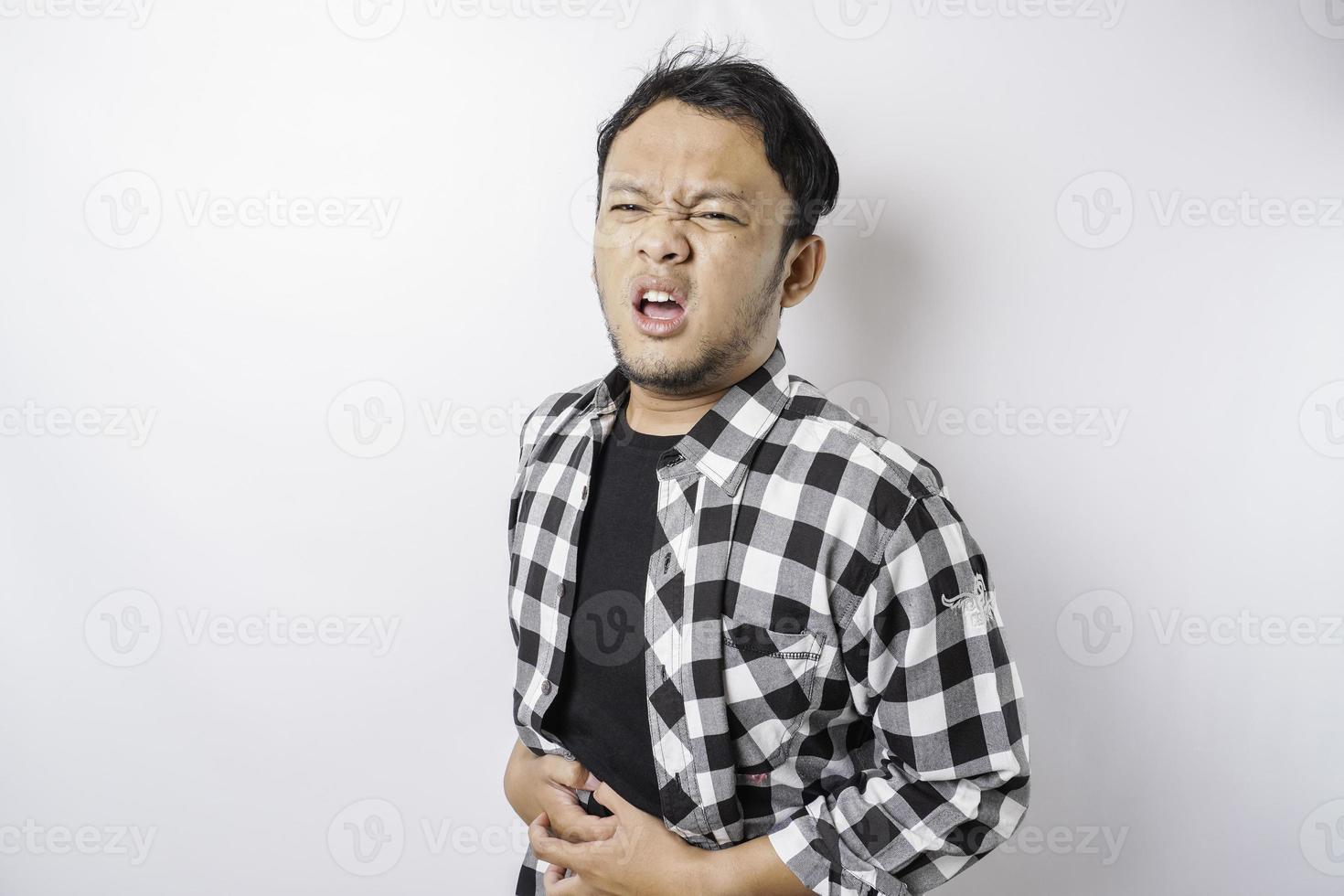 foto de un joven enfermo enfermo que sostiene la mano en el estómago sufre dolor aislado de fondo blanco
