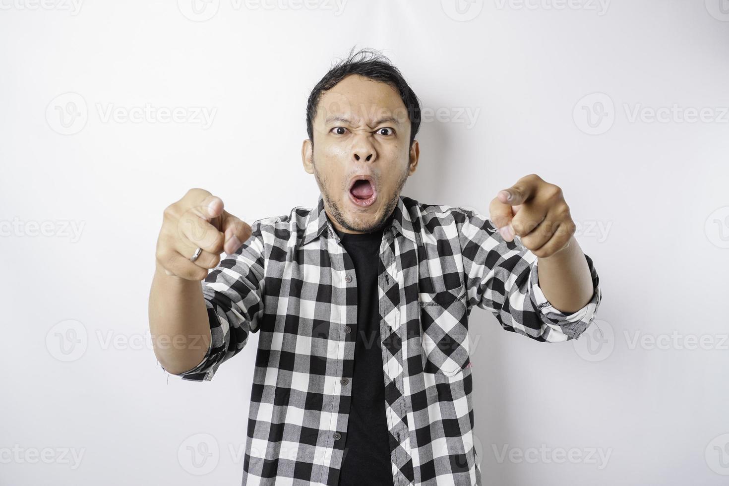 The angry and mad face of Asian man in tartan shirt on isolated white background. photo