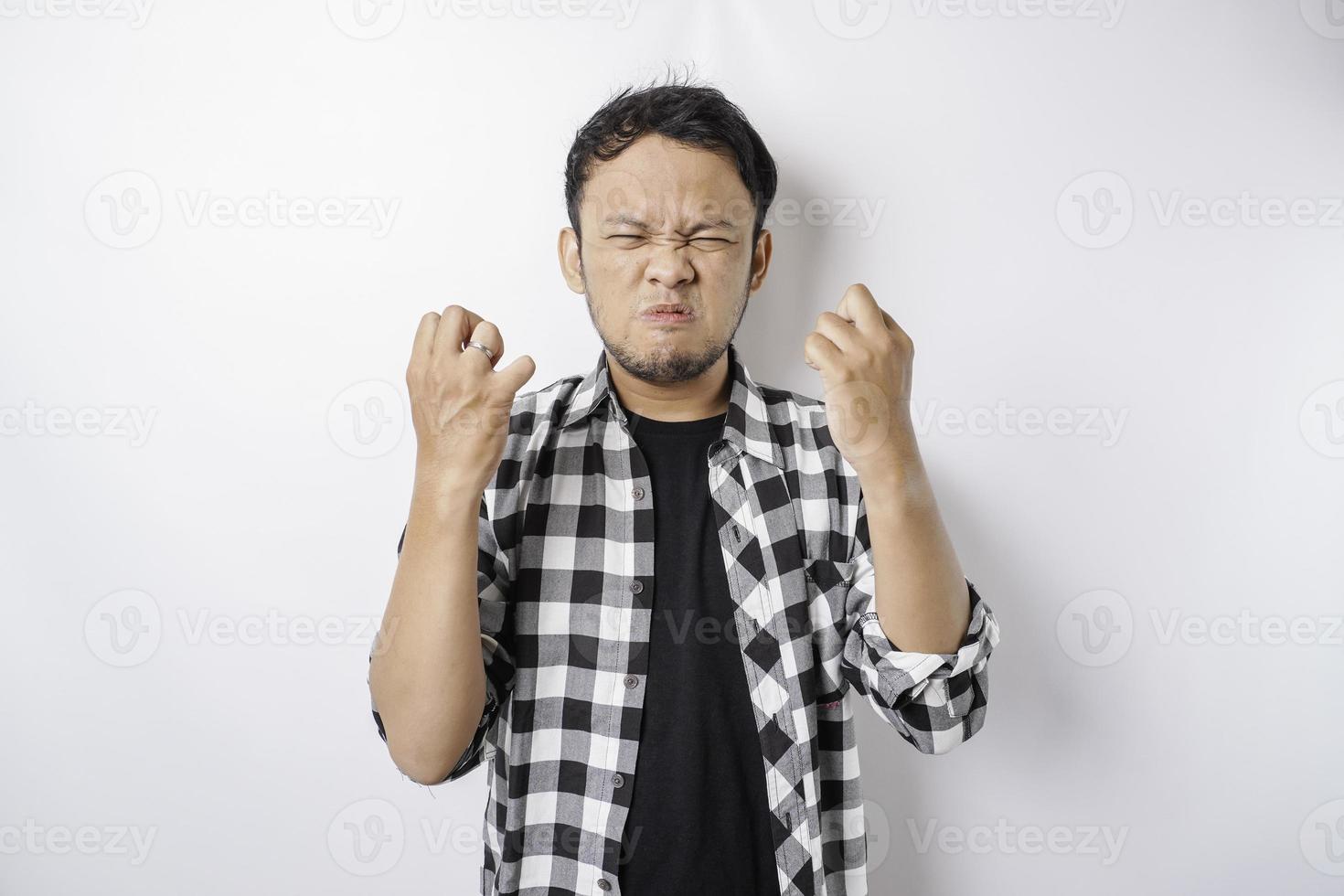 The angry and mad face of Asian man in tartan shirt on isolated white background. photo