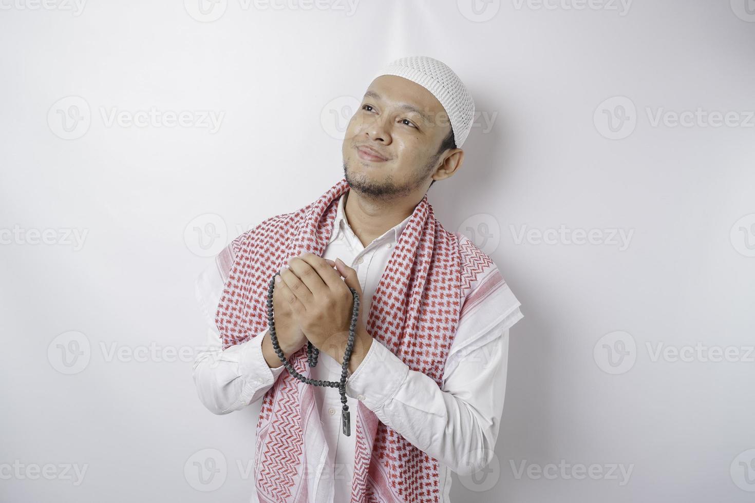 Happy handsome Asian Muslim man is praying to God. photo