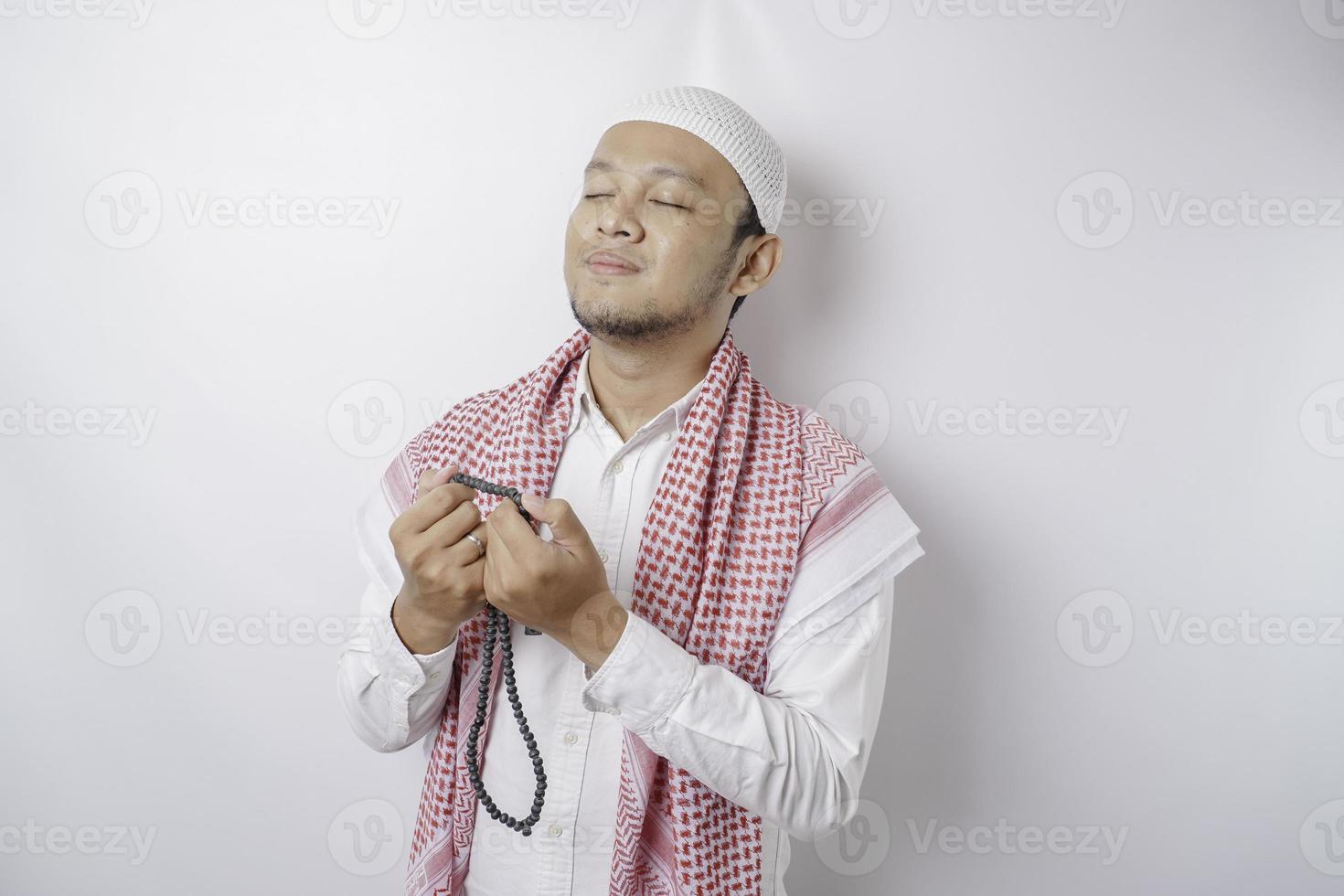 Happy handsome Asian Muslim man is praying to God. photo