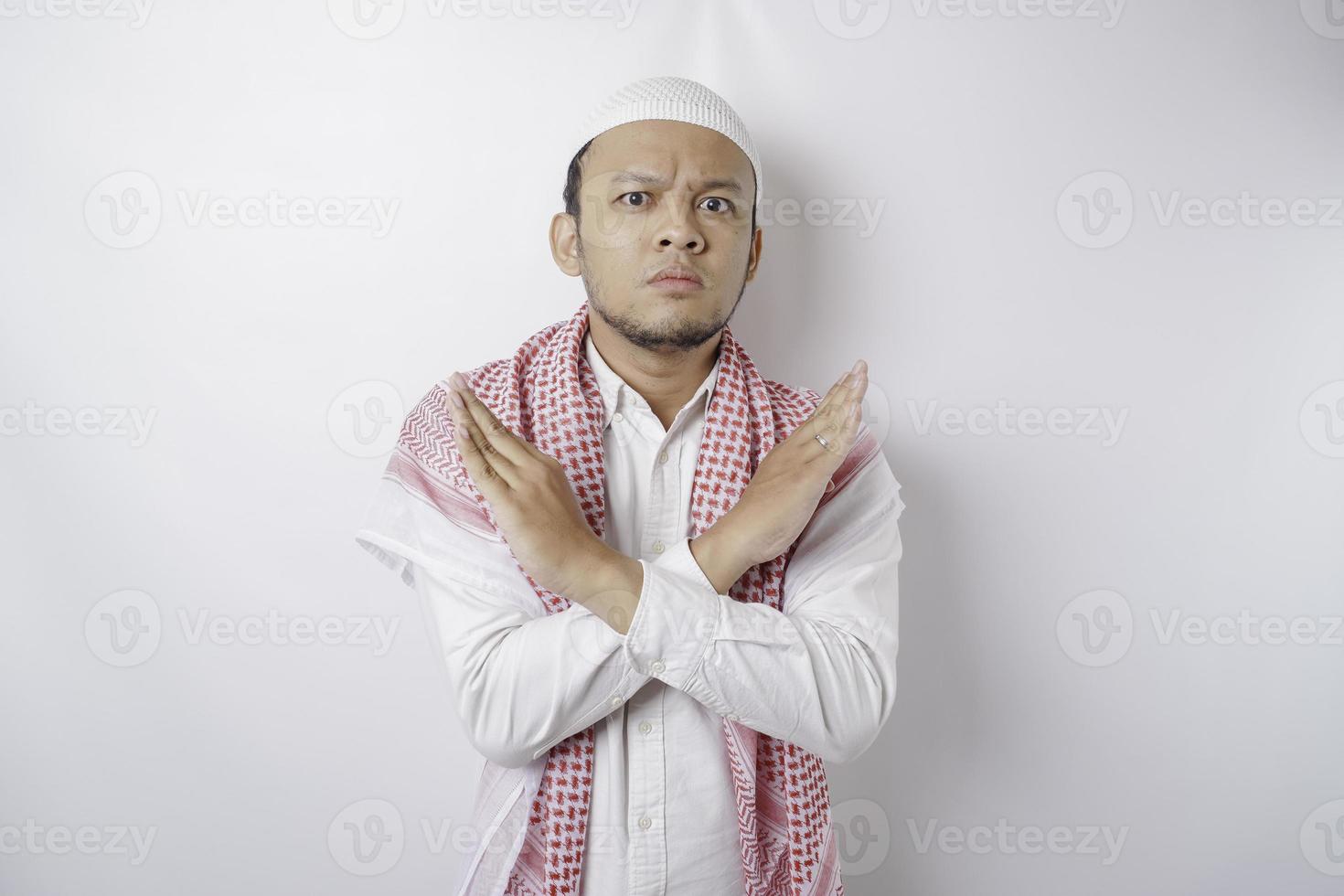 Beautiful Asian Muslim man with hand gesture pose rejection or prohibition with copy space photo