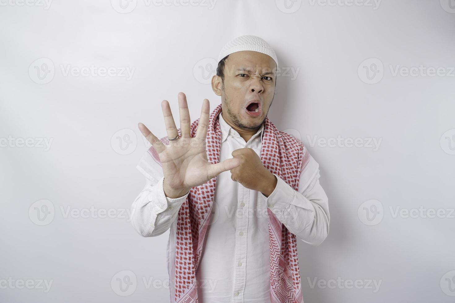 Beautiful Asian Muslim man with hand gesture pose rejection or prohibition with copy space photo