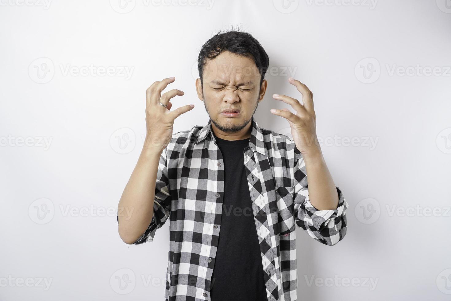 The angry and mad face of Asian man in tartan shirt on isolated white background. photo