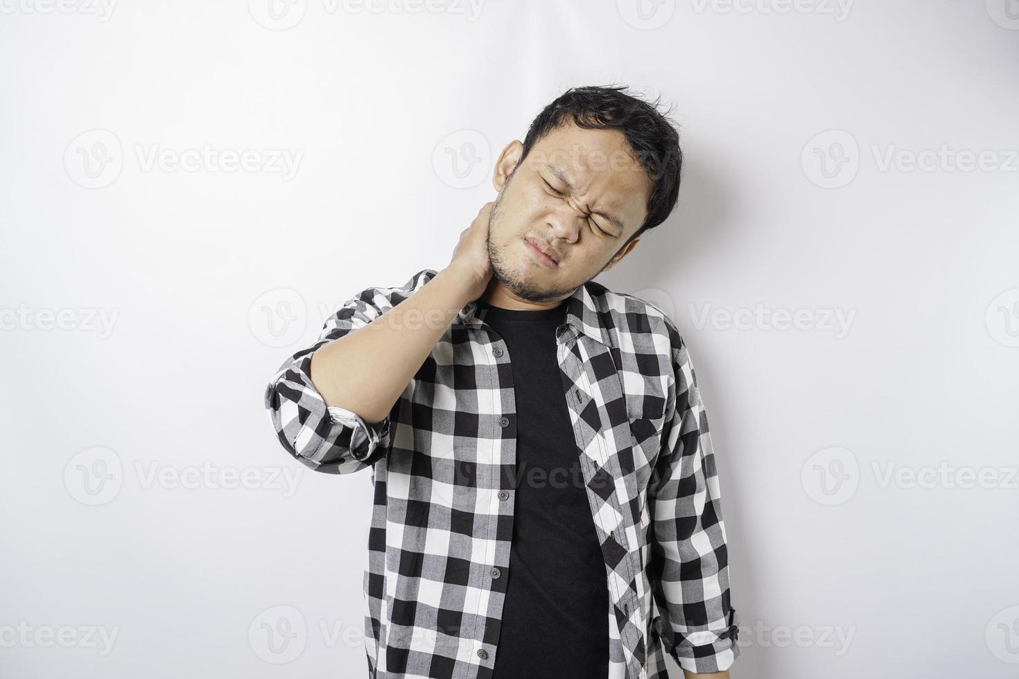 Tired upset young man suffering from pain, muscle spasm at workplace. Fatigue, deadline, pain and incorrect posture photo