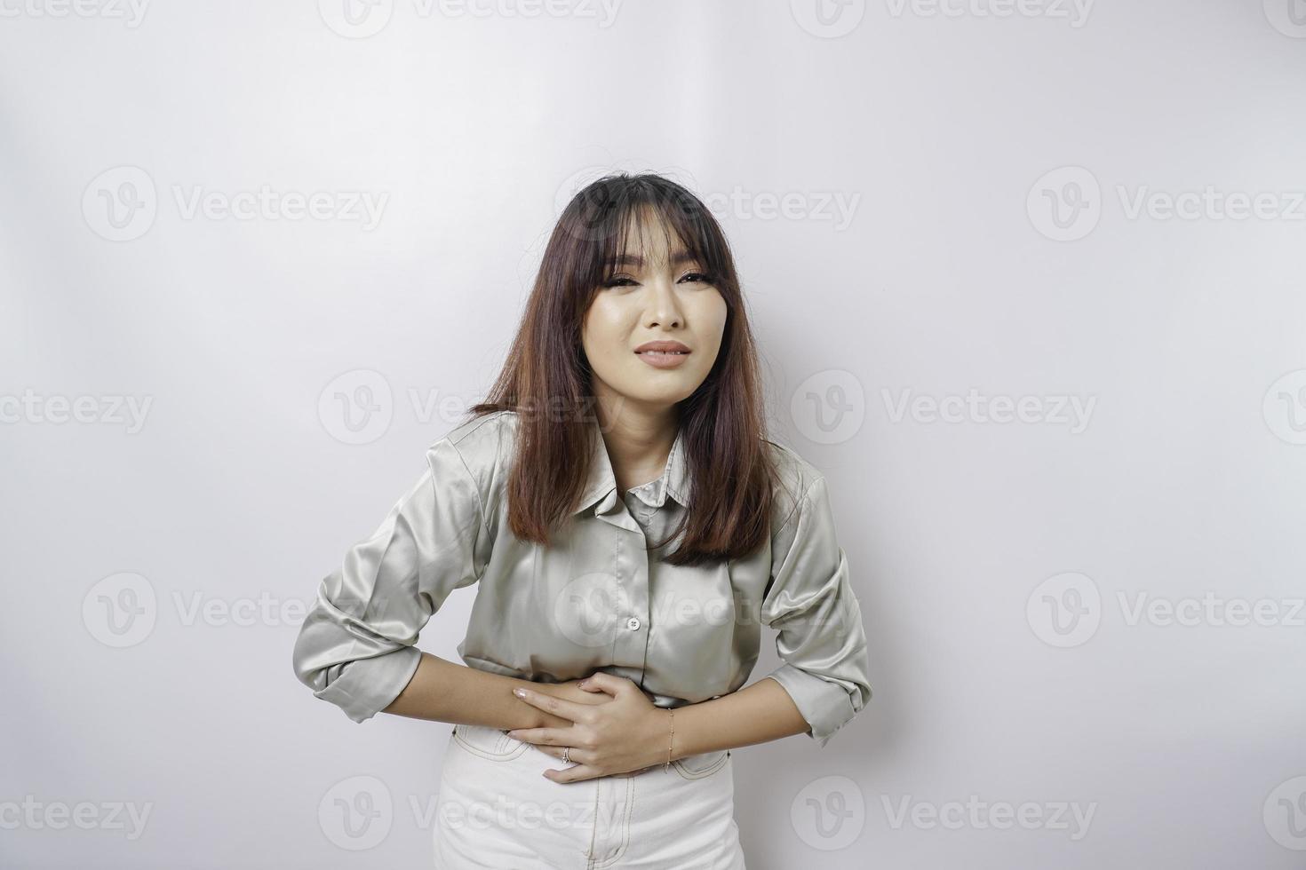 Photo of young unwell sick ill woman hold hand on stomach suffers pain isolated on white background