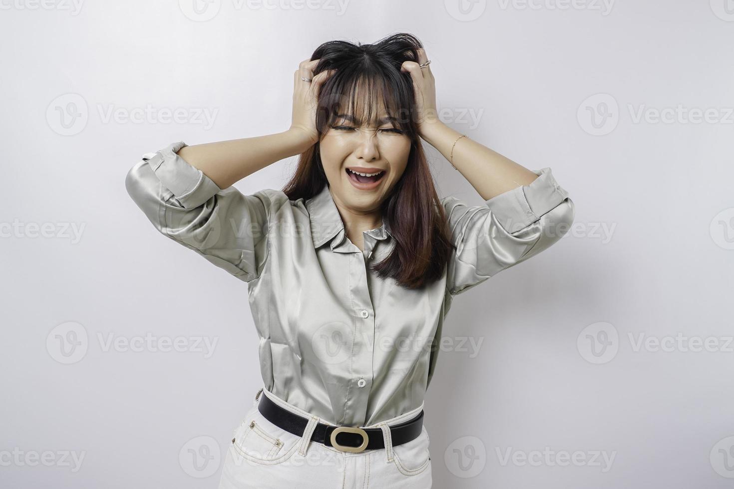 A portrait of an Asian woman wearing a sage green shirt isolated by white background looks depressed photo