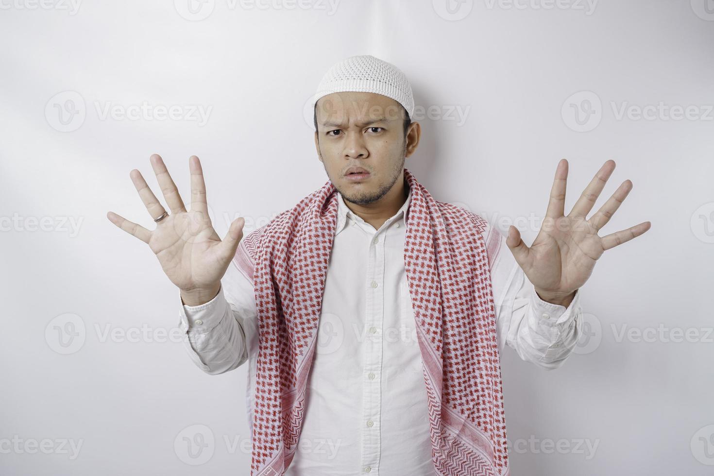 Beautiful Asian Muslim man with hand gesture pose rejection or prohibition with copy space photo