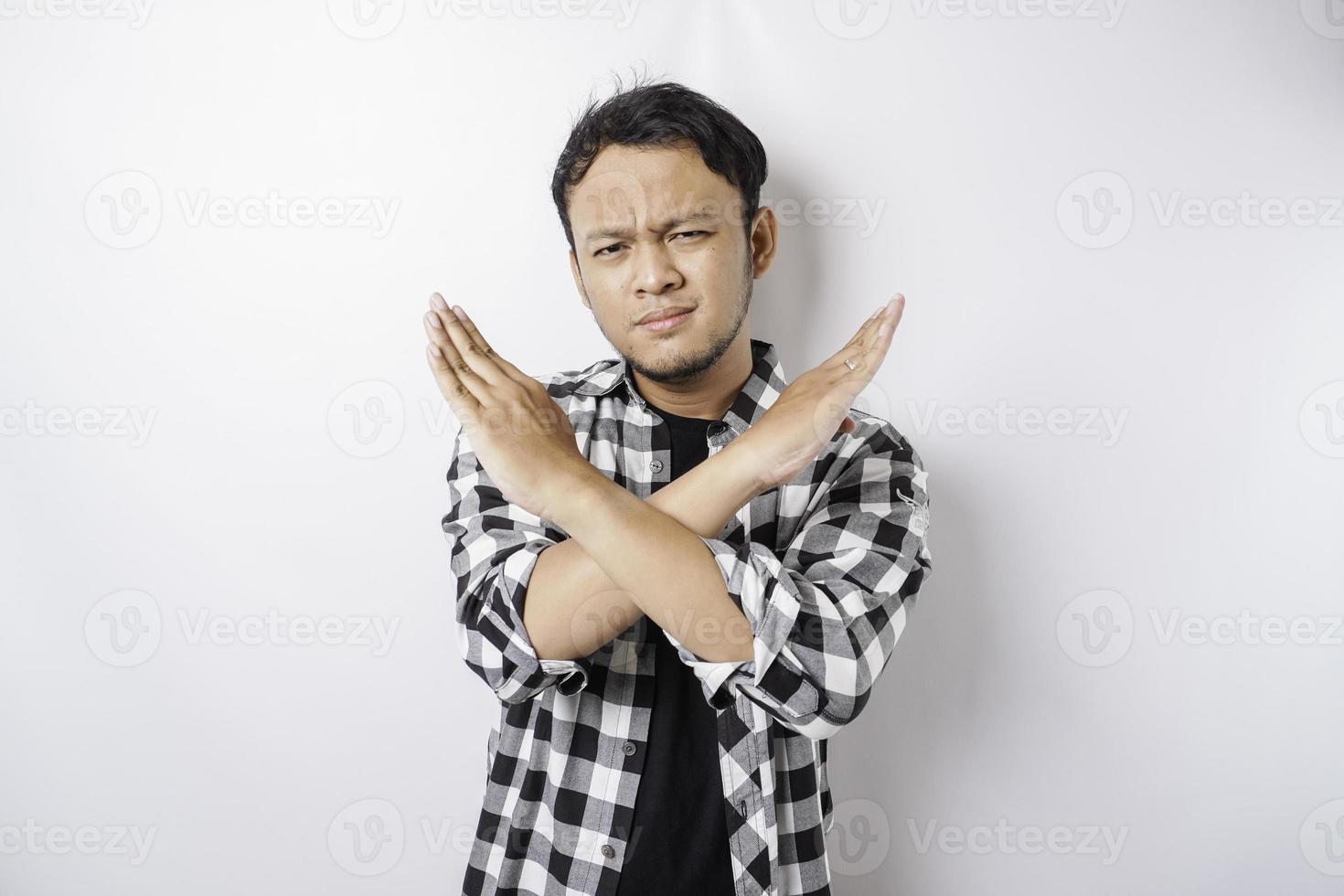 Handsome Asian man with hand gesture pose rejection or prohibition with copy space photo