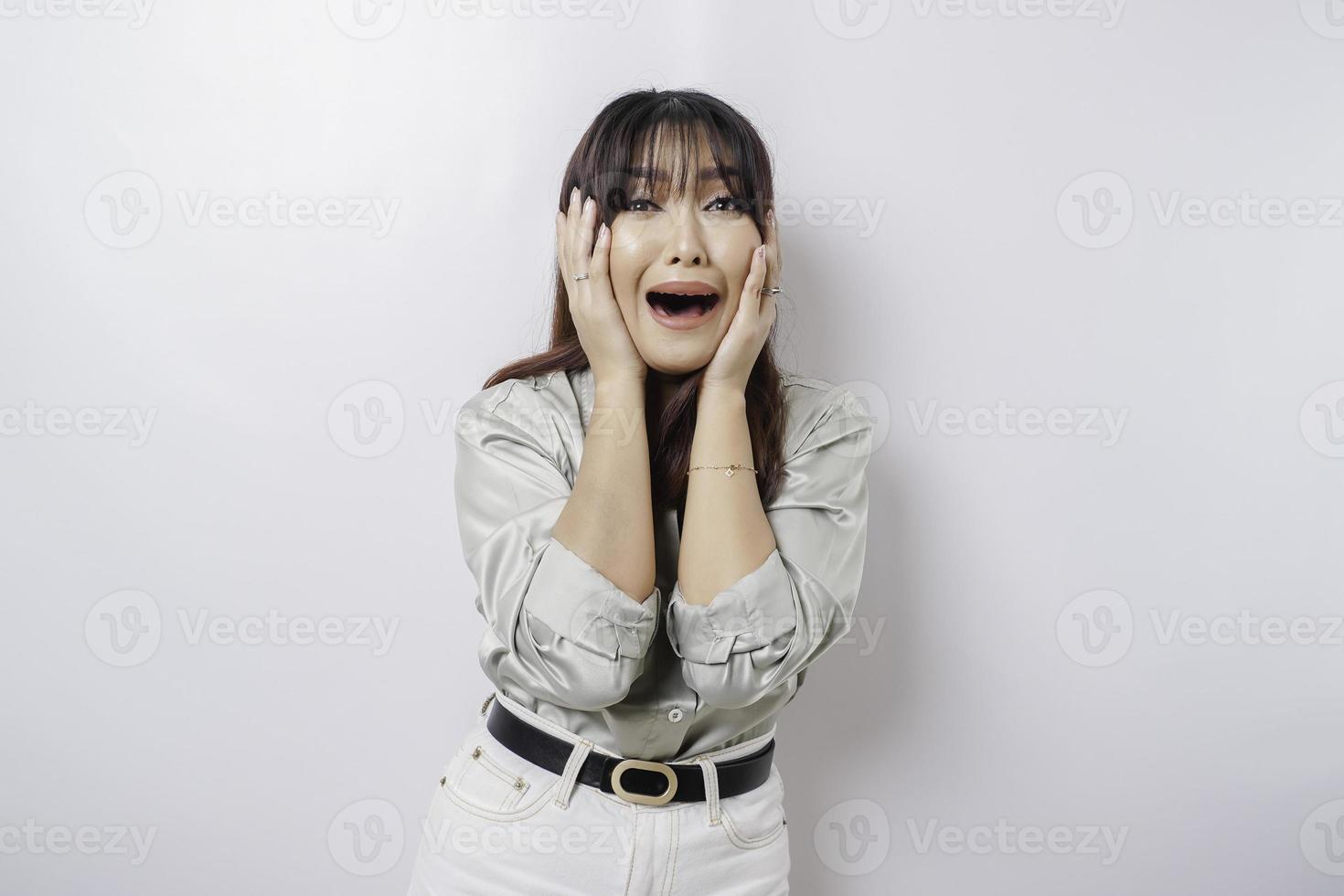 A portrait of an Asian woman wearing a sage green shirt isolated by white background looks depressed photo