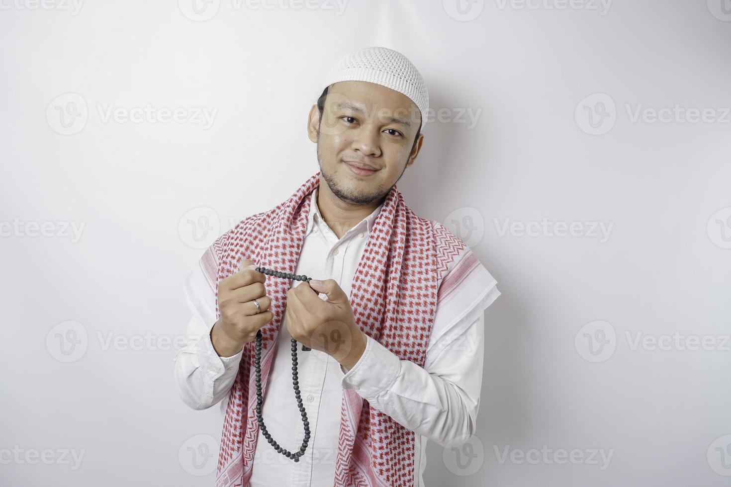 A portrait of a happy Asian Muslim man smiling isolated by white background photo