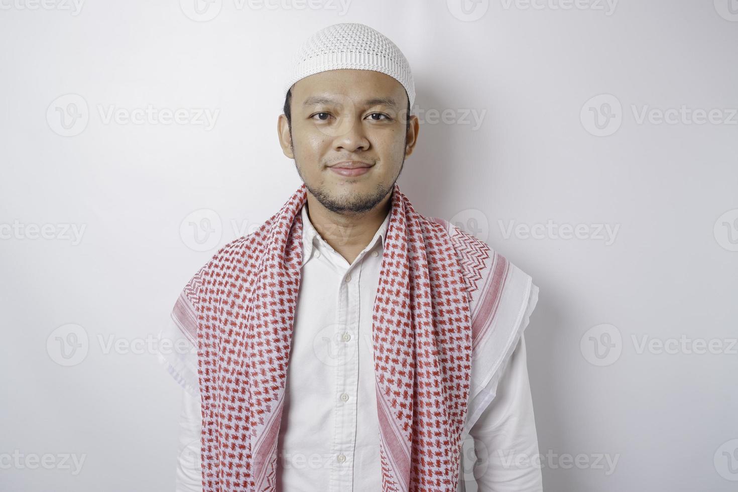 A portrait of a happy Asian Muslim man smiling isolated by white background photo