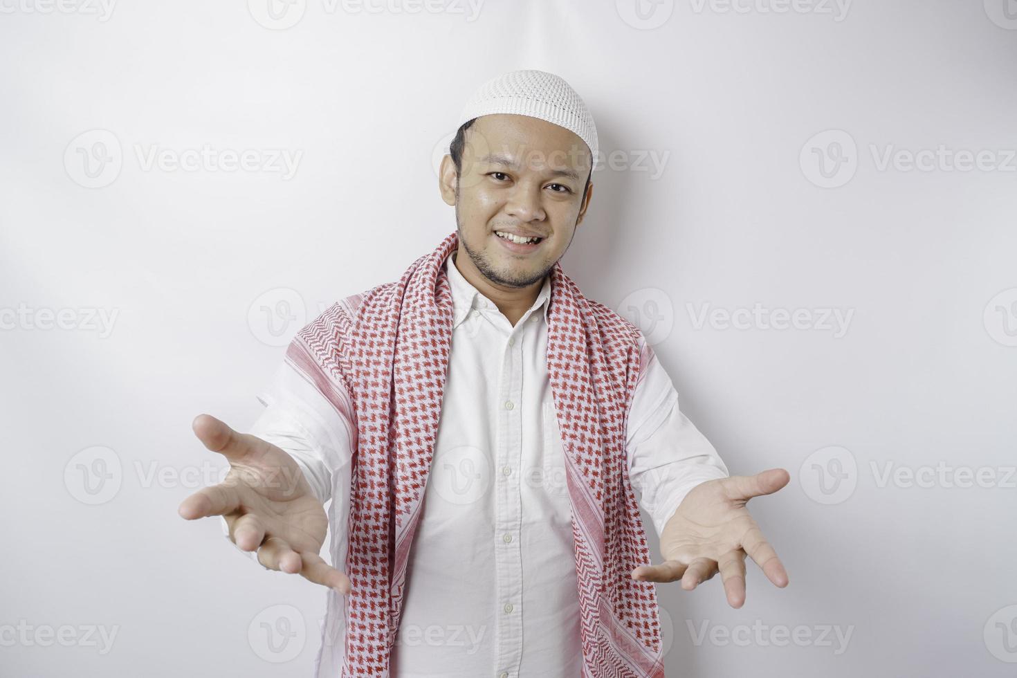 Young Asian Muslim man presenting an idea while smiling on isolated white background photo