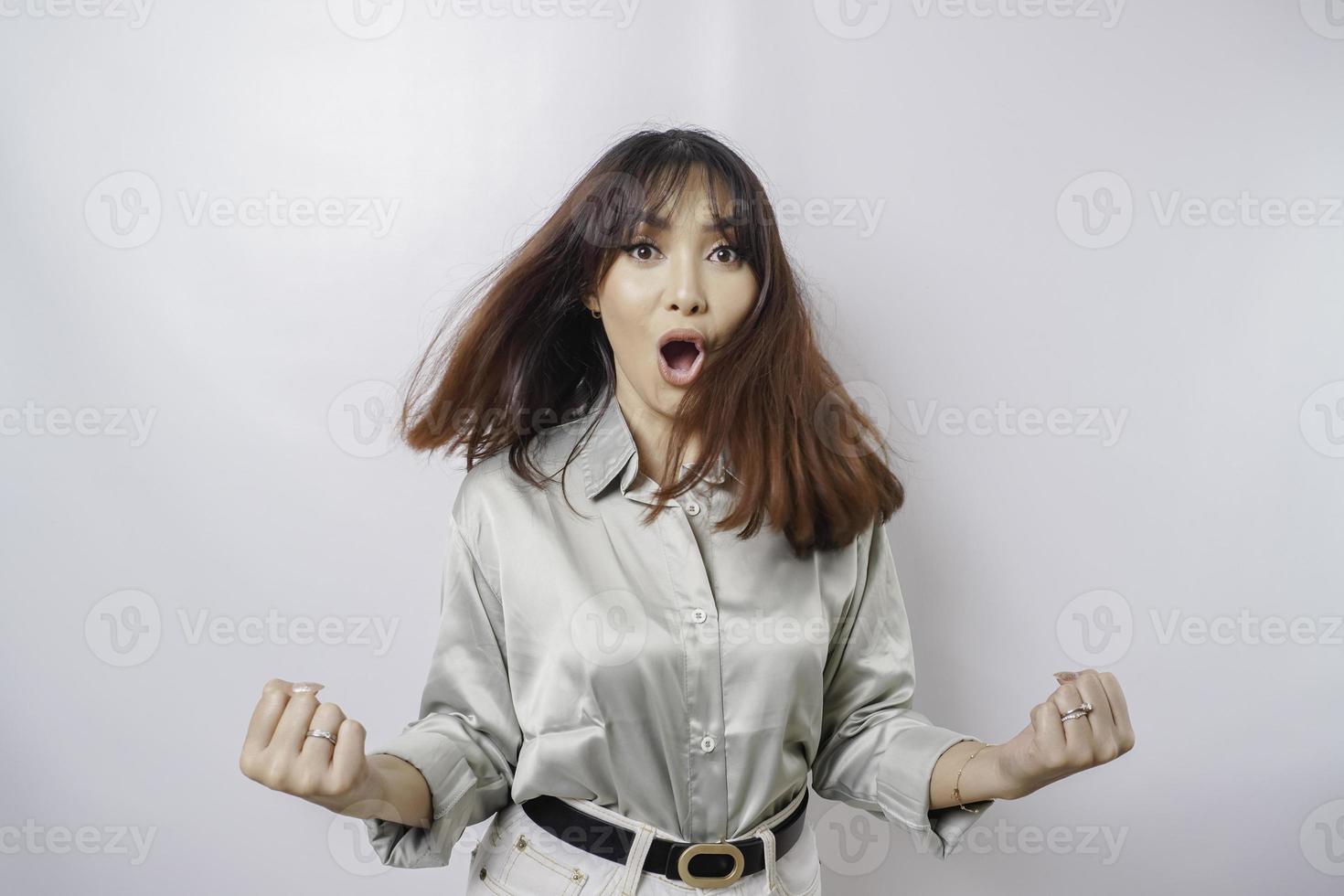 una joven asiática con una expresión feliz y exitosa que usa una camisa verde salvia aislada de fondo blanco foto