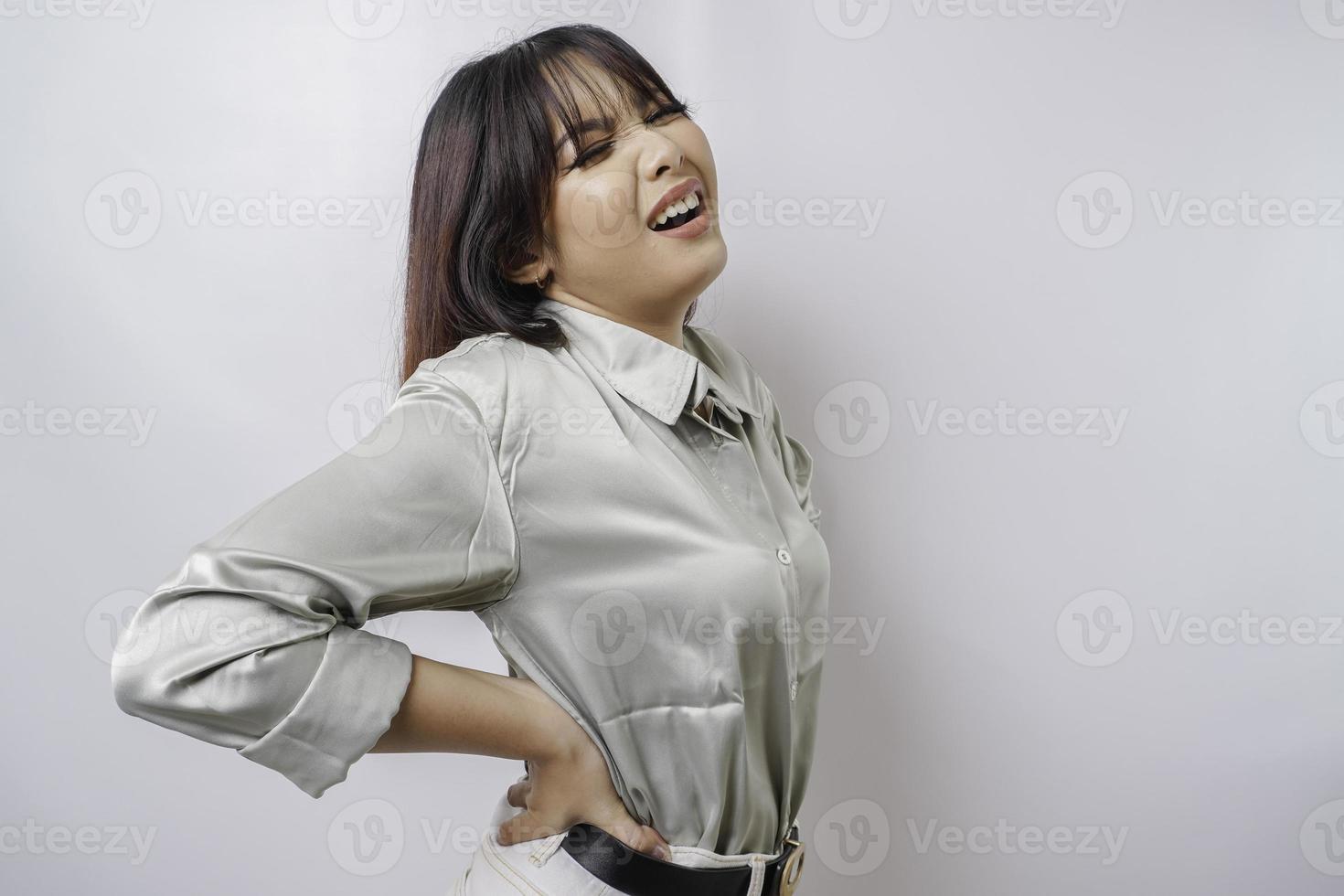 Tired upset young woman suffering from back pain, muscle spasm at workplace. Fatigue, deadline, pain and incorrect posture photo