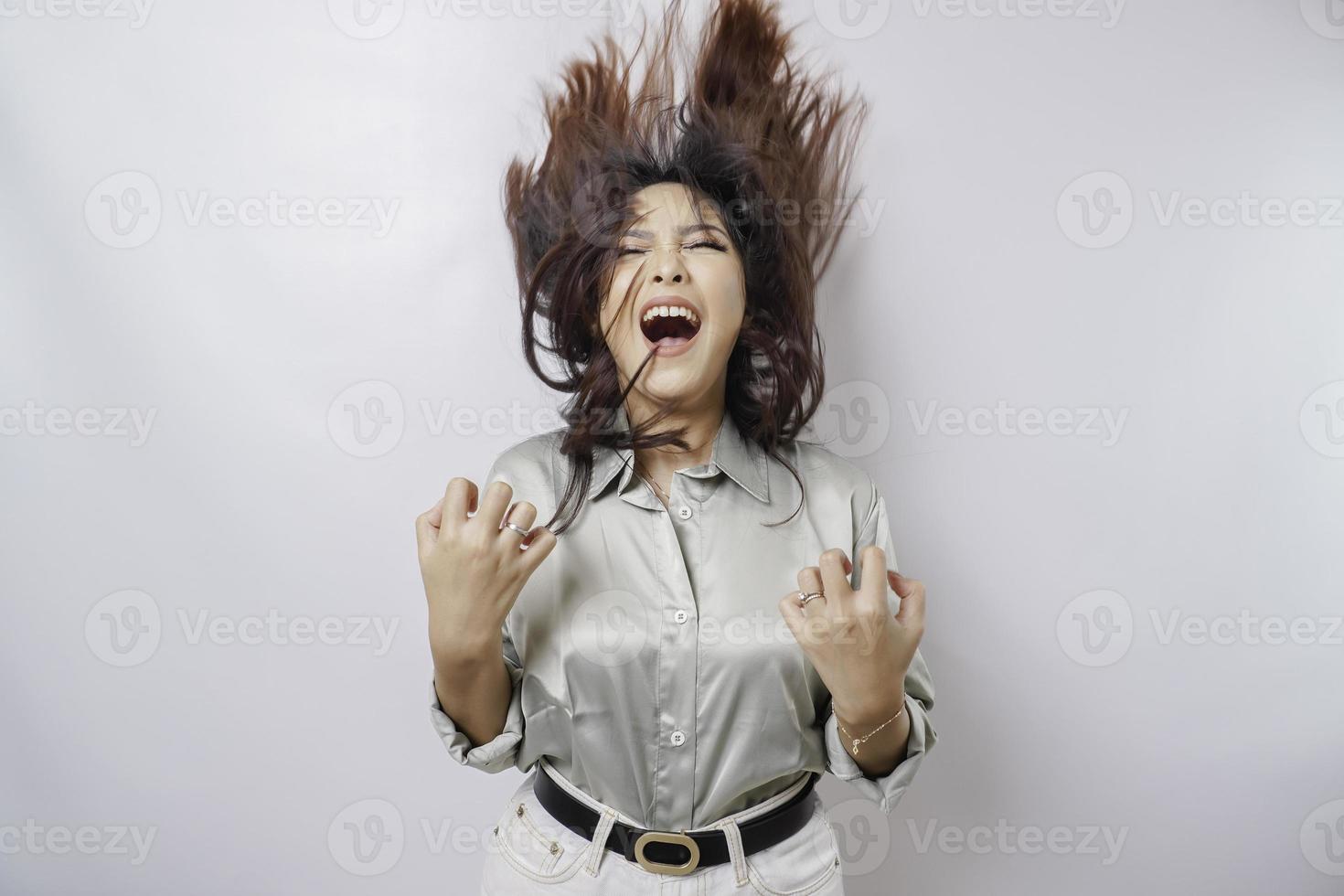 A young Asian woman with a happy successful expression wearing sage green shirt isolated by white background photo