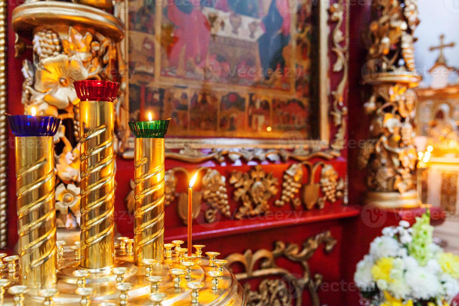 Iglesia Ortodoxa. cristiandad. decoración interior festiva con velas encendidas e icono en la iglesia ortodoxa tradicional en vísperas de pascua o navidad. religión fe orar símbolo. foto