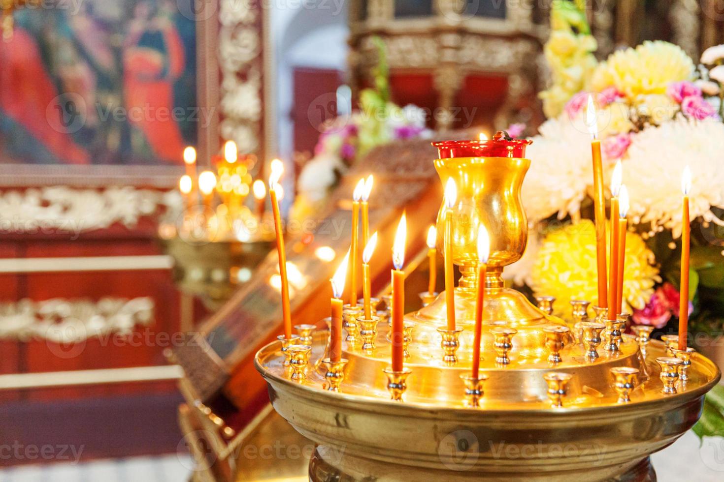 Iglesia Ortodoxa. cristiandad. decoración interior festiva con velas encendidas e icono en la iglesia ortodoxa tradicional en vísperas de pascua o navidad. religión fe orar símbolo. foto