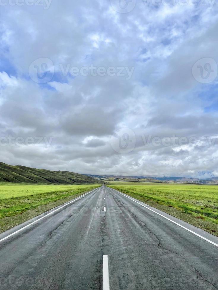 el camino se adentra en la distancia en las montañas, una parte del tracto chuisky, altai, rusia foto