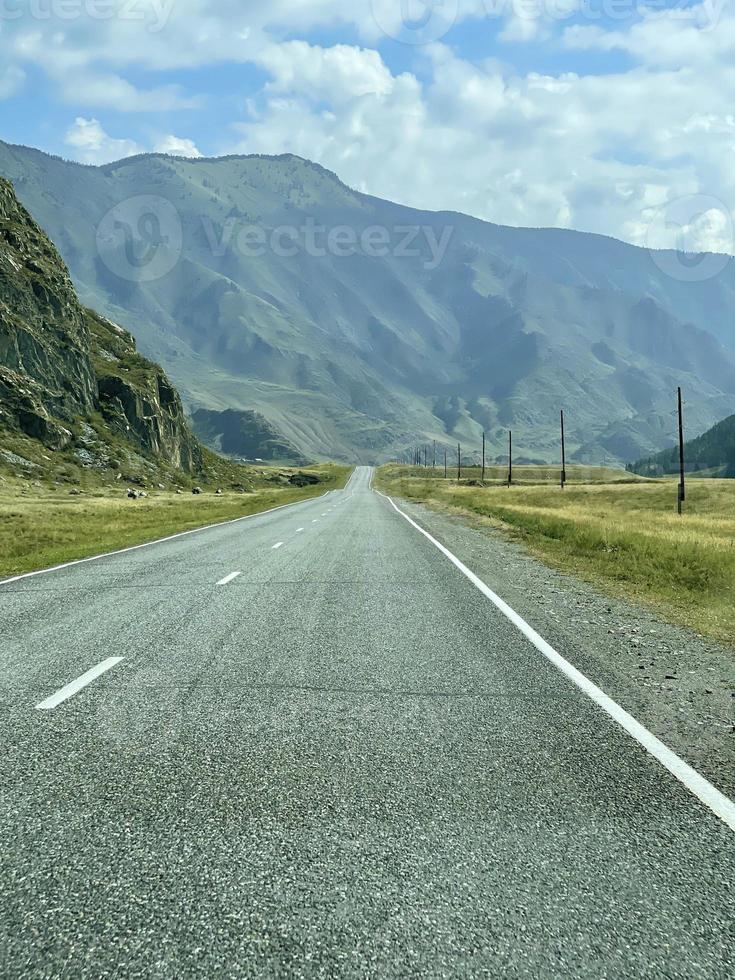el camino se adentra en la distancia en las montañas, una parte del tracto chuisky, altai, rusia foto