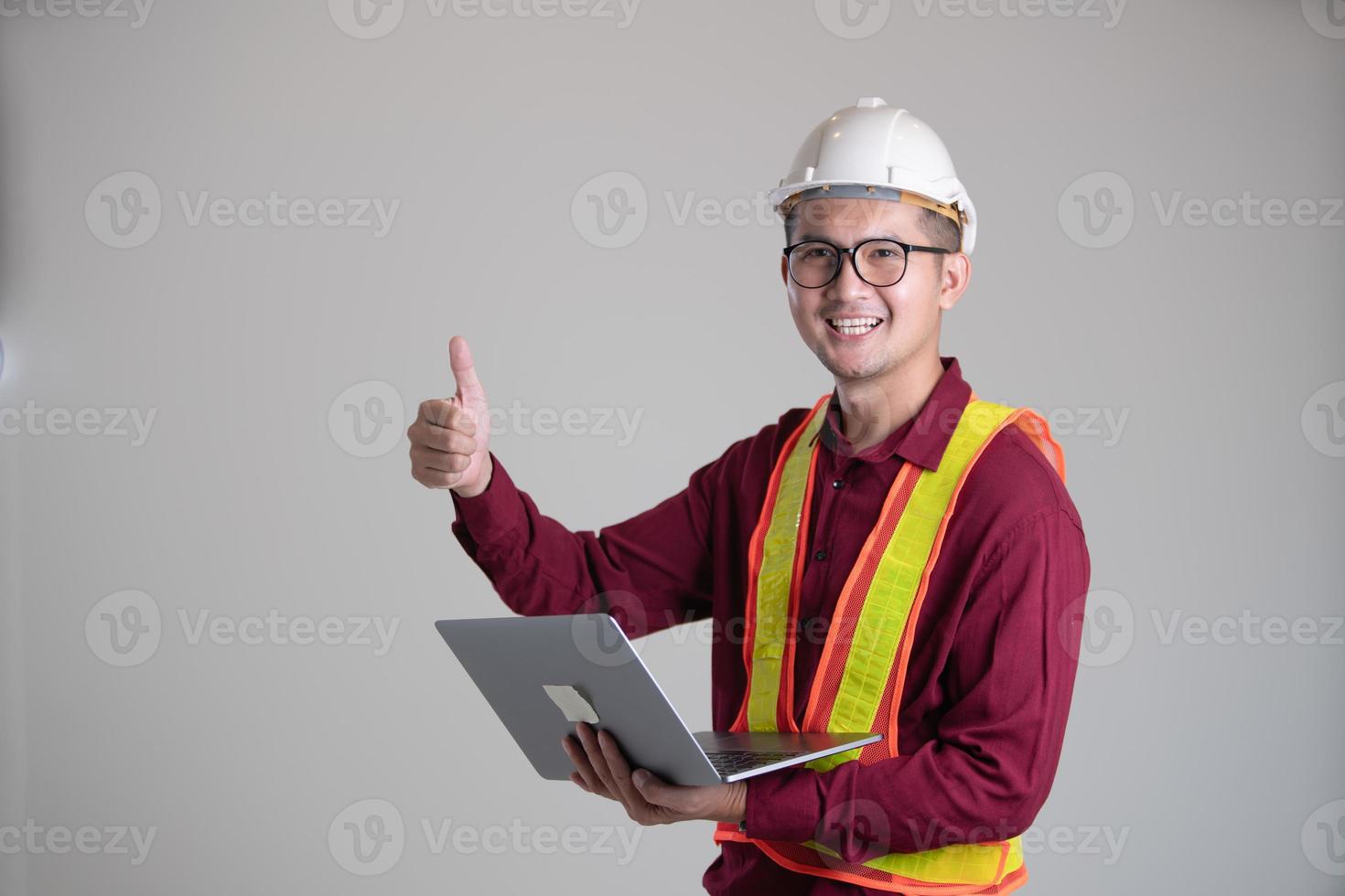 Thumbs up of engineering and holding laptop photo