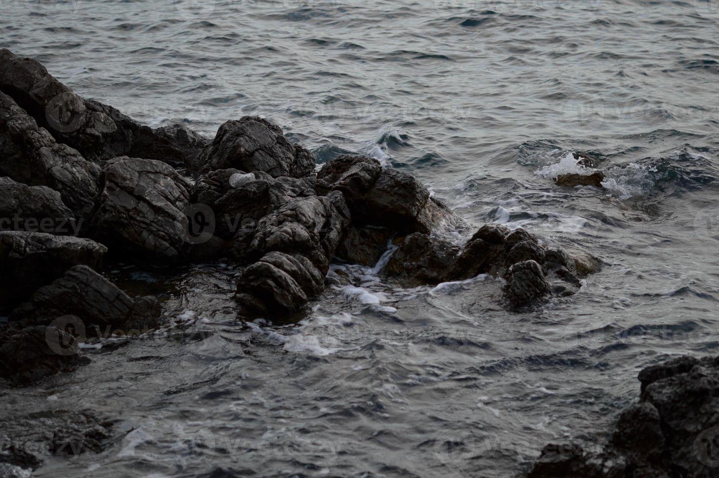 Sea waves crashing into rocks photo