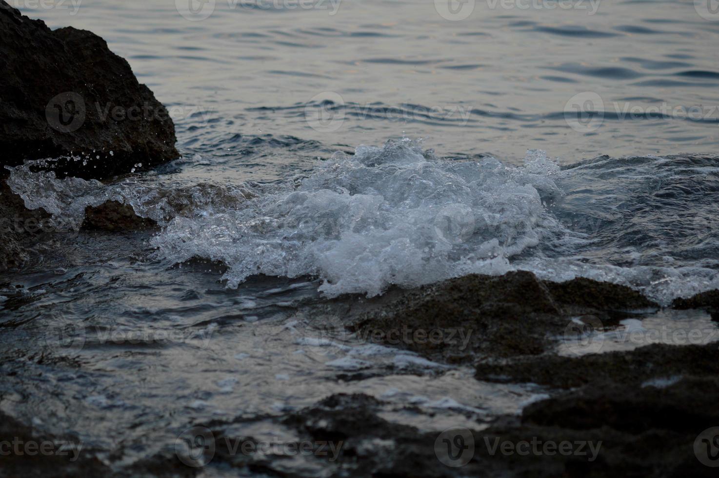 Sea waves crashing into rocks photo