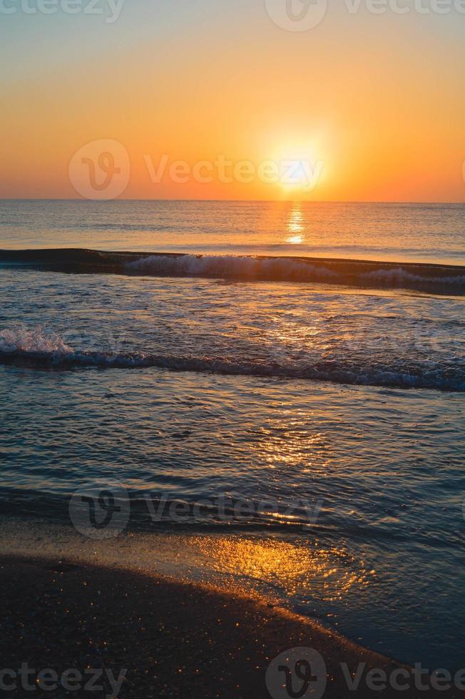 Beautiful summer sunset at the beach, waves and sand photo