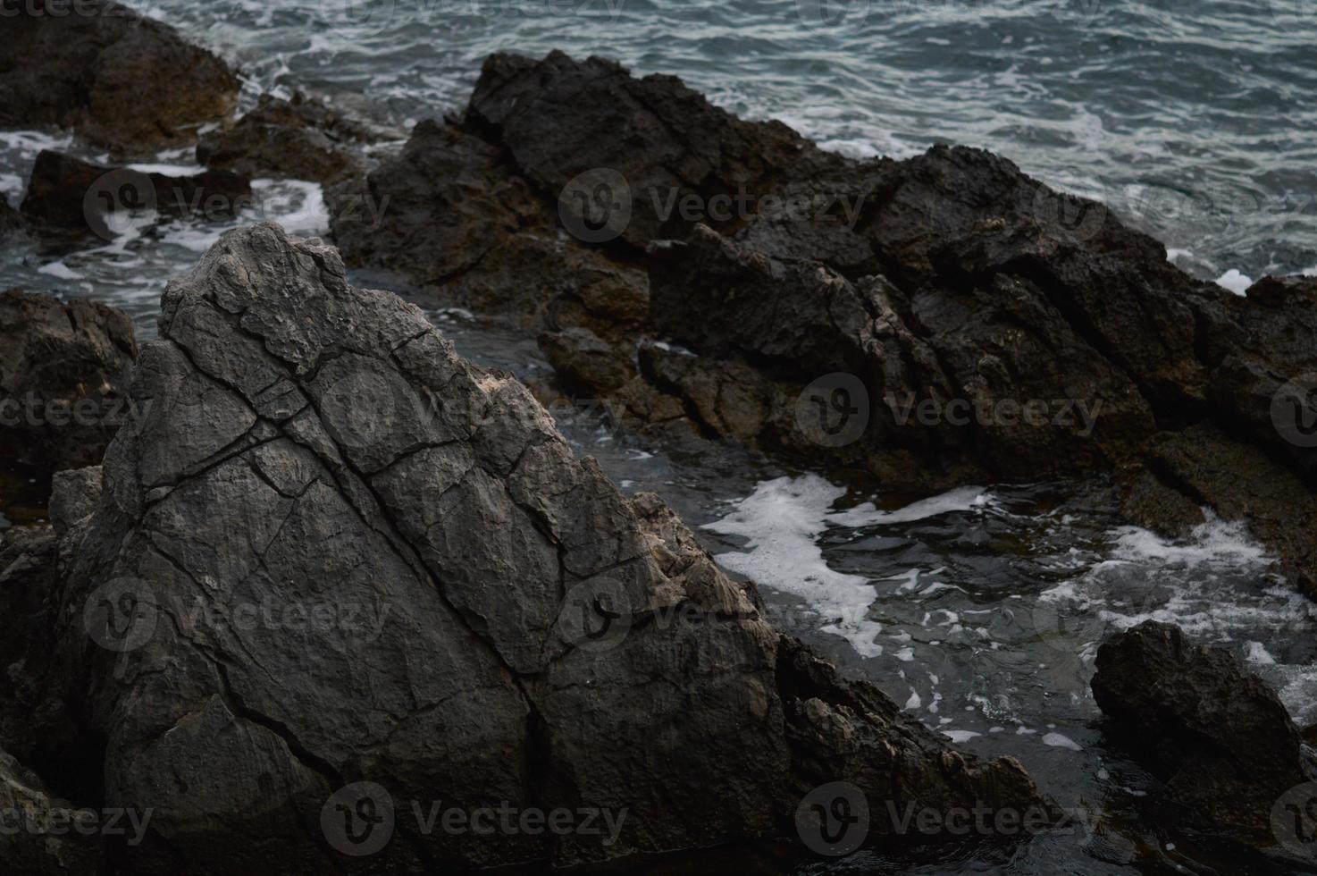 Sea waves crashing into rocks. photo