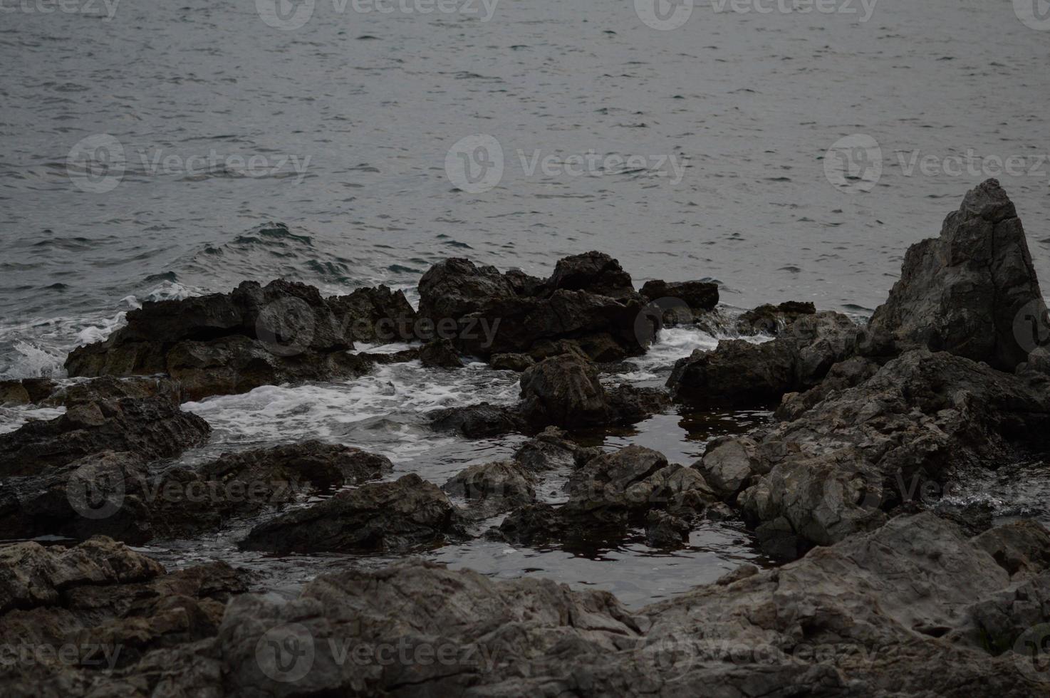 Sea waves crashing into rocks. photo