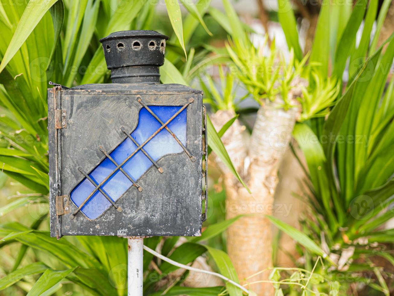 A navigation lamp with arrows to guide the way made of old iron, blue. Located in a public park photo