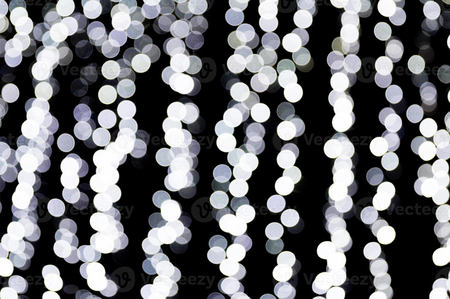 Abstract bokeh of white city lights on black background. defocused and blurred many round light photo