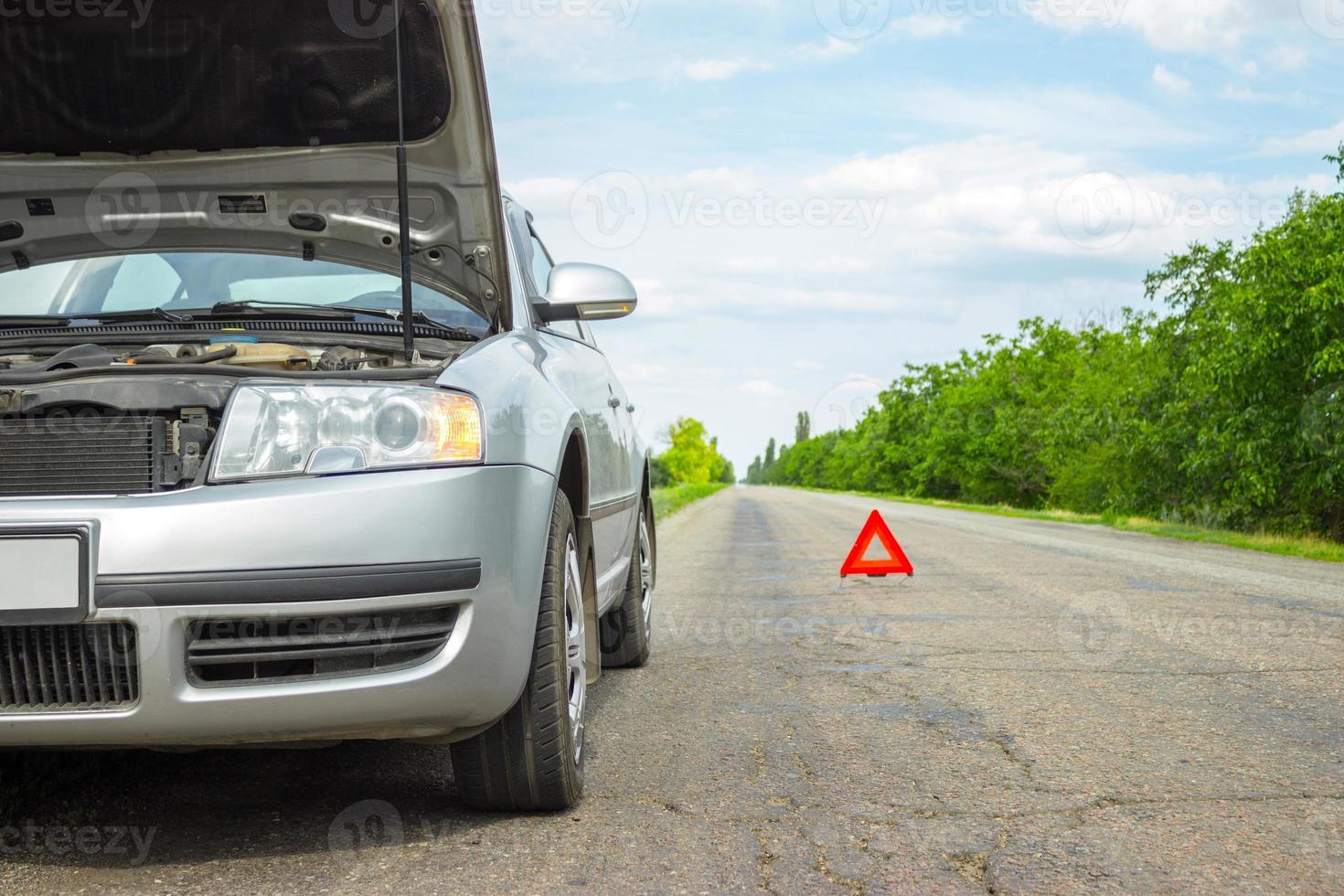 Car with problems and a red triangle to warn other road users photo