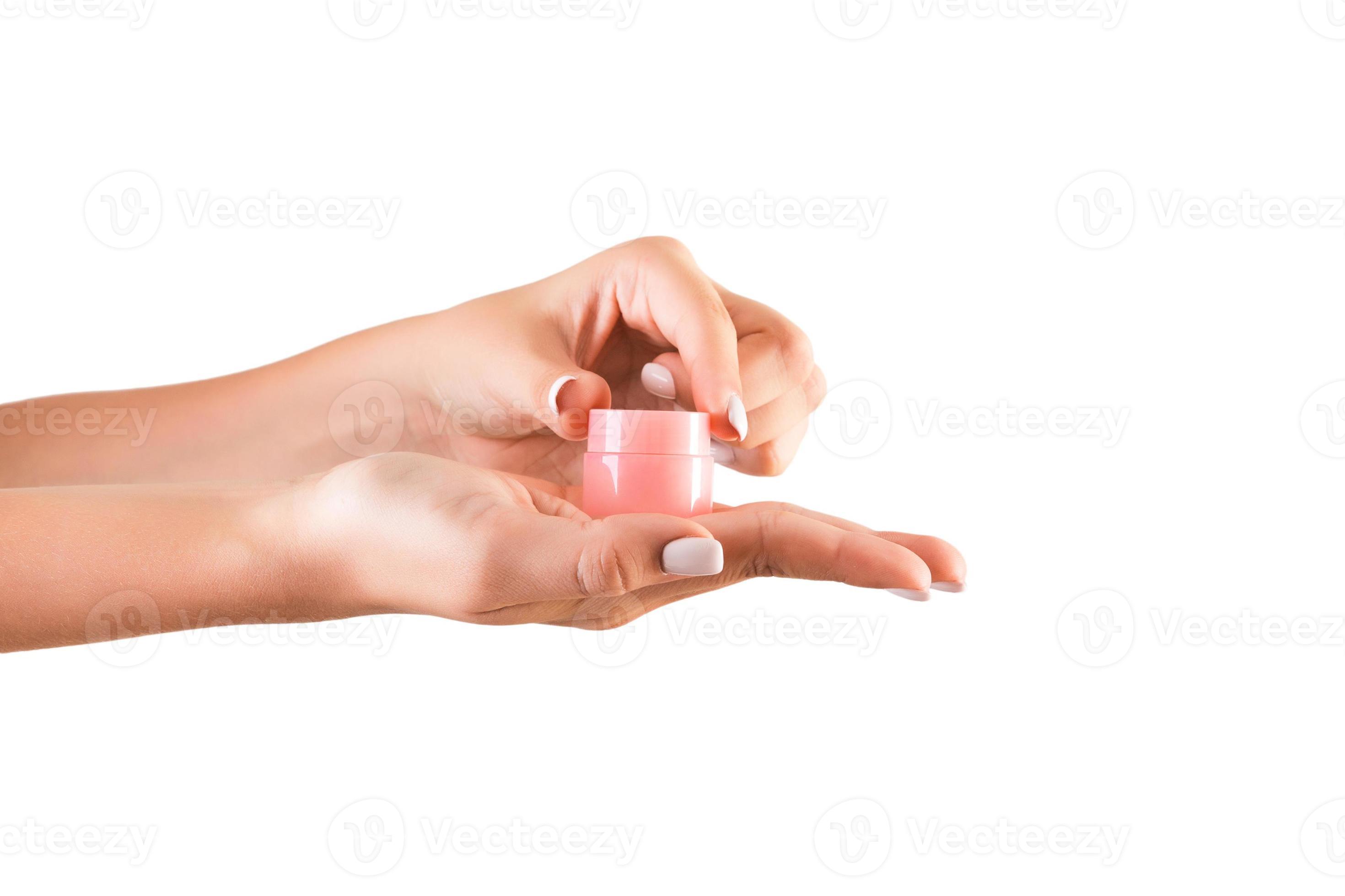Female hand holding cream bottle of lotion isolated. Girl opening jar