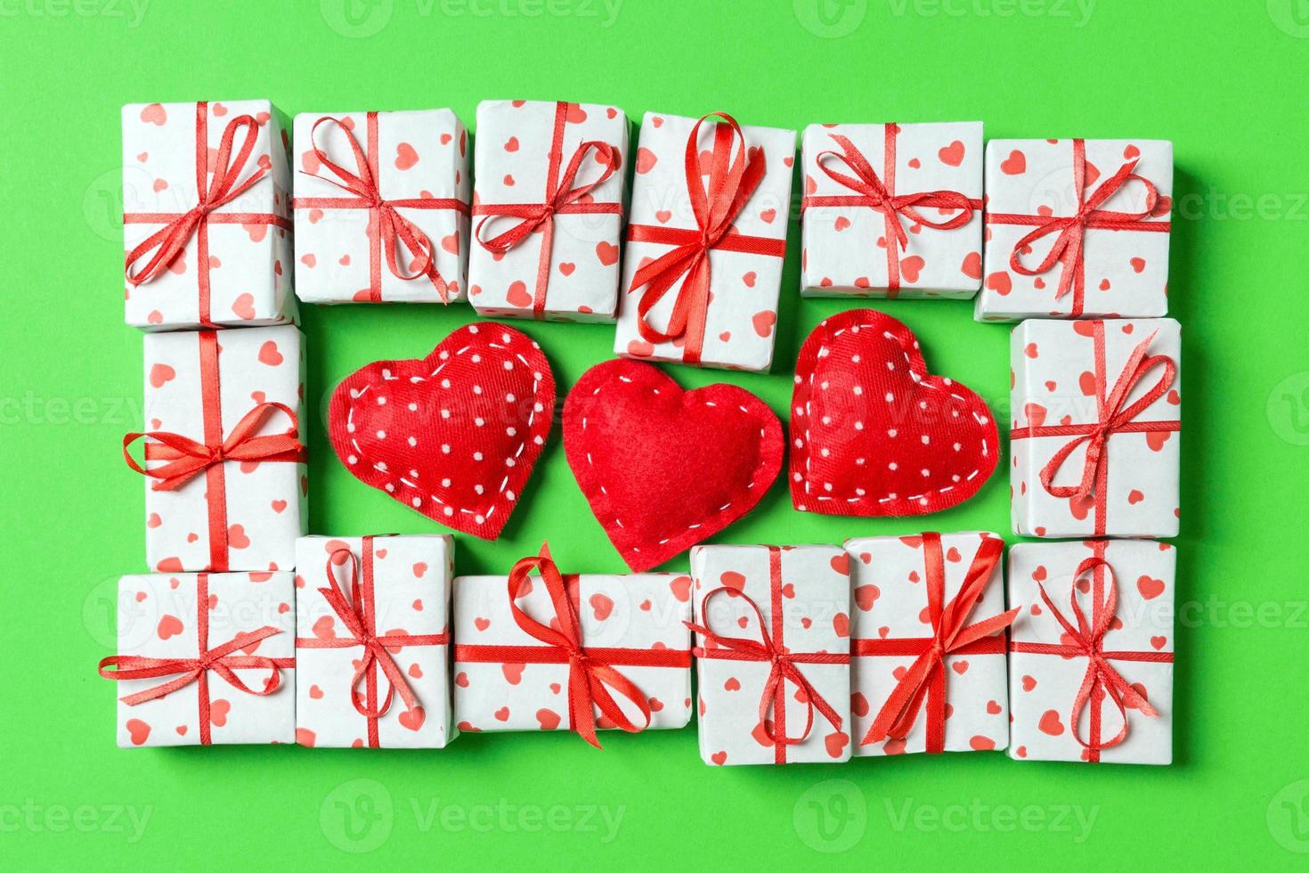 Composition of holiday white gift boxes and red textile hearts on colorful background. Valentine's day concept photo