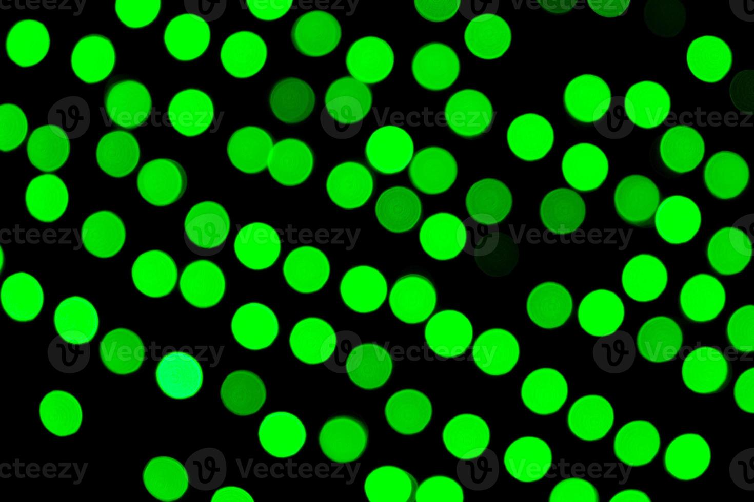 Unfocused abstract green bokeh on black background. defocused and blurred many round light photo