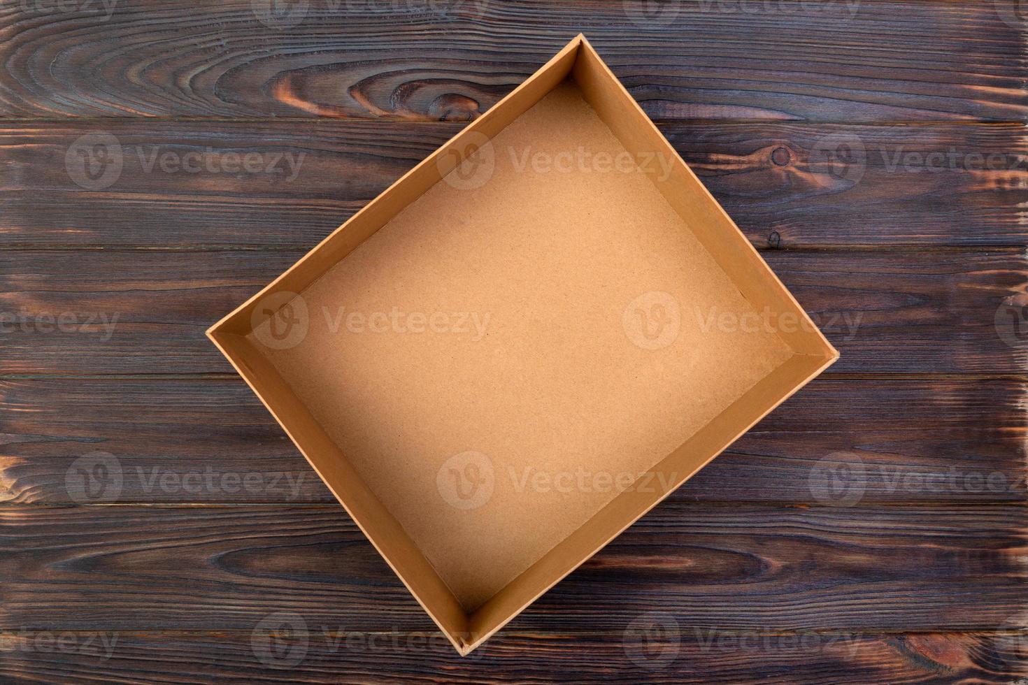 Open Cardboard box on a dark table, wooden background. top view photo