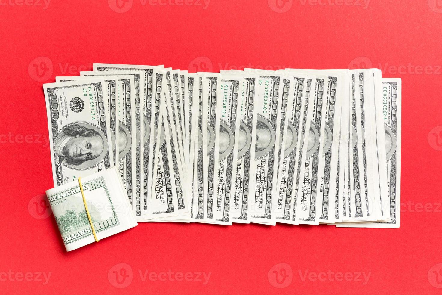 Close up of 100 dollar bills in a row on colorful background. Top view of salary concept photo